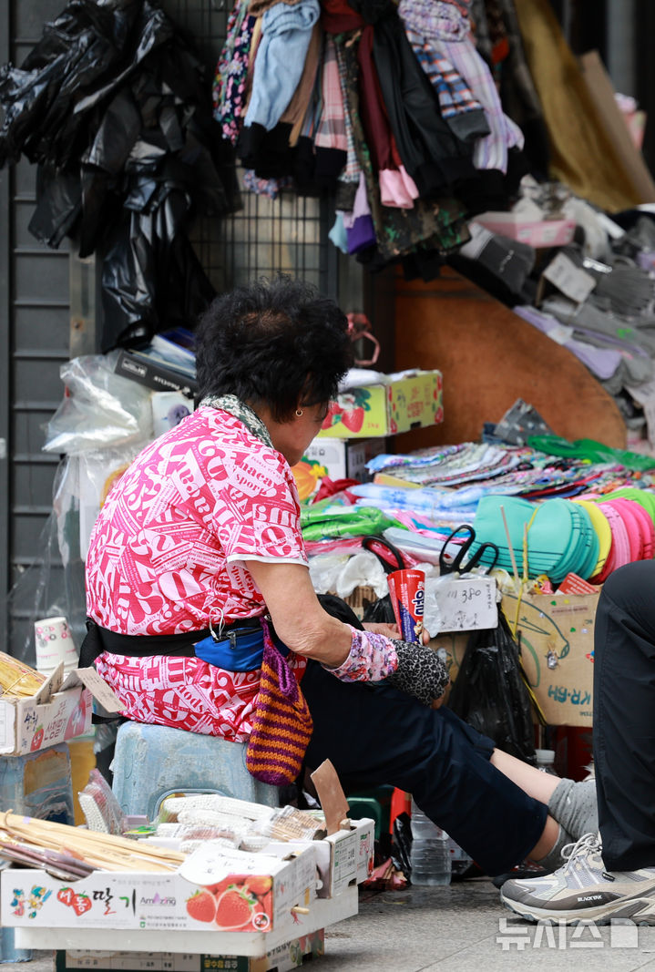 [서울=뉴시스] 이영환 기자 = 찜통 더위가 이어지고 있는 23일 오후 서울 종로구의 도로변 상점에서 상인이 아이스크림들 들고 있다. 2025.07.23. 20hwan@newsis.com