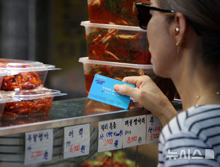 [서울=뉴시스] 조성우 기자 = 서울 시내의 한 전통시장에서 한 시민이 반찬을 구매하고 있다. 2025.07.23. xconfind@newsis.com