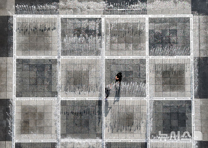 [대구=뉴시스] 이무열 기자 = 폭염이 연일 계속된 23일 대구 서구 평리공원 바닥분수에서 어린이들이 물놀이를 하고 있다. 2025.07.23. lmy@newsis.com