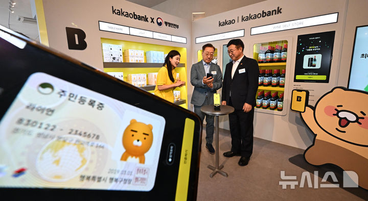 [서울=뉴시스] 지난해 7월 23일 윤호영 카카오뱅크 대표와 카카오뱅크 모바일신분증 서비스를 체험하고 있다. (공동취재) 2025.07.23. photo@newsis.com