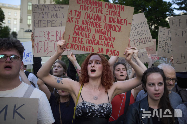 [키이우=AP/뉴시스] 23일(현지 시간) 우크라이나 키이우 대통령궁 앞에서 시위대가 반부패 기관의 권한을 제한할 수 있는 정부의 법안 통과에 반대하며 손팻말을 들고 구호를 외치고 있다. 2025.07.24.