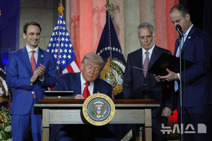 [워싱턴=AP/뉴시스] 도널드 트럼프 미국 대통령이 7월 23일 워싱턴의 앤드루 W. 멜론 강당에서 열린 AI 정상회의에 참석해 연설한 뒤 AI 관련 행정명령에 서명하고 있다. 뉴욕법원은 트럼프 행정명령 중 인문학기금 지급중단과 환수에 제동 명령을 내렸다. 2025.07.27.