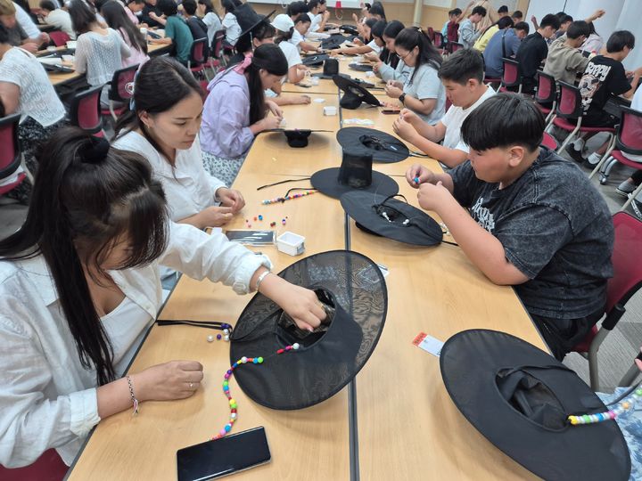 [전주=뉴시스] 24일 전주비전대학교 국제교류원 비전한국어센터에서 열린 단기 어학연수에 참가한 몽골 청소년들이 '1초 갓' 체험 프로그램에서 갓끈을 직접 제작하고 있다. (사진=전주비전대학교 제공) 2025.07.24. photo@newsis.com *재판매 및 DB 금지