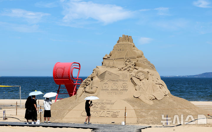 [포항=뉴시스] 이무열 기자 = 제9회 영일대 샌드페스티벌 개막을 이틀 앞둔 24일 경북 포항시 북구 영일대해수욕장을 찾은 관광객들이 다양한 모래조각 작품을 관람하고 있다. 2025.07.24. lmy@newsis.com