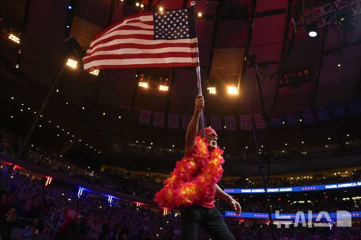 [뉴욕=AP/뉴시스] 미국 프로레슬링의 전설 '헐크 호건(본명 테리 진 볼레아)'이 24일(현지 시간) 71세를 일기로 별세했다. 사진은 헐크 호건이 지난해 10월27일 미국 뉴욕 매디슨 스퀘어 가든에서 열린 공화당 대선 후보 도널드 트럼프 전 대통령의 유세 무대에 올라 지지 연설 전 성조기를 흔드는 모습. 2025.07.25.