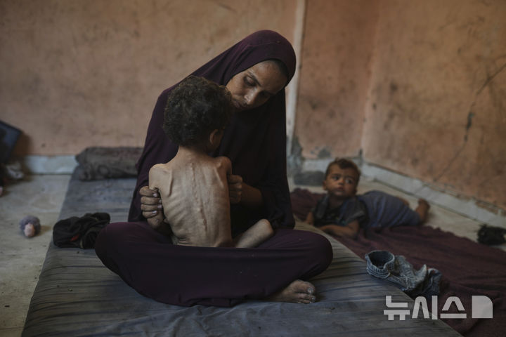 [가자시티=AP/뉴시스] 23일(현지 시간) 가자시티 샤티 난민 캠프에 머물고 있는 야잔 아부 풀(2)이 엄마 품에 안겨있다. 2025.07.25.