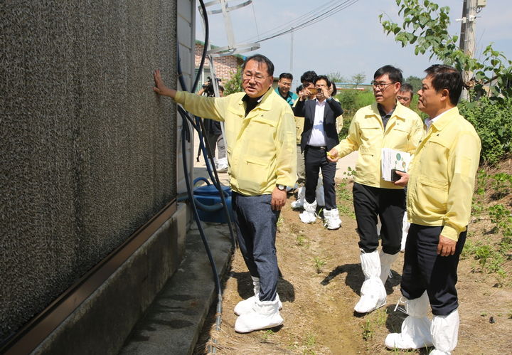 [정읍=뉴시스] 지난 24일 지속적인 폭염으로부터 축산피해를 최소화하고자 이학수 정읍시장과 전북도 김종훈 경제부지사 등이 정읍의 한 양계농장을 방문했다. 김종훈 부지사(앞 왼쪽)와 이학수 시장(앞 오른쪽)이 축사 외벽 방열벽의 상태를 살피고 있다. *재판매 및 DB 금지