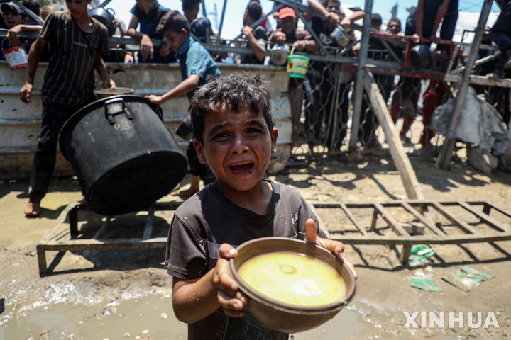 [가자시티=신화/뉴시스]지난 7월24일(현지 시간) 가자지구 가자시티 자선 급식소에서 한 팔레스타인 어린이가 구호 음식을 받아 들고 있다. 2025.10.23.