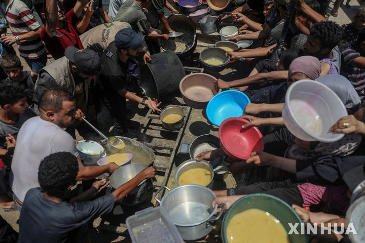 [가자시티=신화/뉴시스] 지난 24일(현지 시간) 가자지구 가자시티 자선 급식소에서 팔레스타인 주민들이 구호 음식을 받고 있다. 2025.07.26.