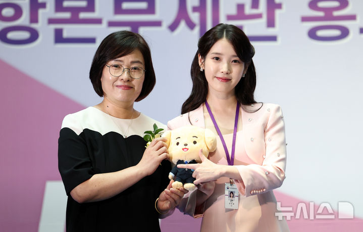 [인천공항=뉴시스] 김선웅 기자 = 가수 겸 배우 아이유가 25일 인천국제공항에서 열린 인천공항본부세관 홍보대사 위촉식에서 기념선물을 전달받고 있다. 2025.07.25. mangusta@newsis.com