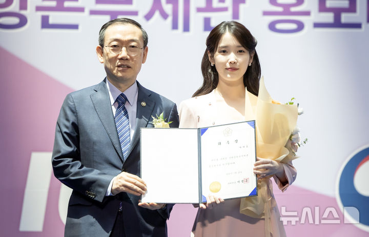 [인천공항=뉴시스] 김선웅 기자 = 가수 겸 배우 아이유가 25일 인천국제공항에서 열린 인천공항본부세관 홍보대사 위촉식에서 이명구 관세청장으로부터 위촉장을 받고 있다. 2025.07.25. mangusta@newsis.com