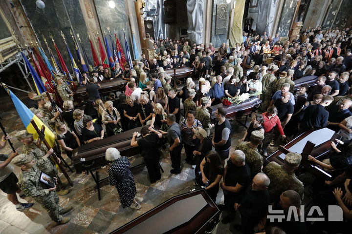 [리비우=AP/뉴시스] 지난 25일(현지 시간) 우크라이나 리비우에서 러시아 포로로 잡혀 숨진 군인 12명의 장례식을 거행되고 있다. 2025.07.27.
