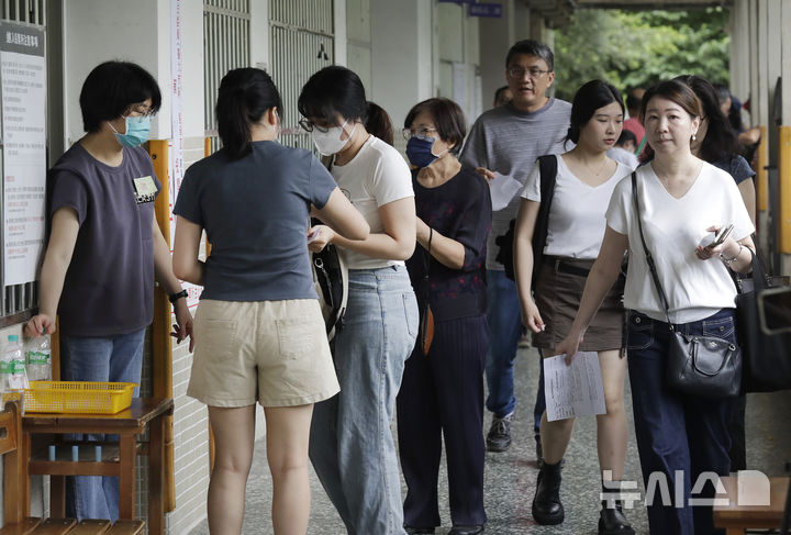 [타이베이=AP/뉴시스] 대만 야당 의원 24명에 대한 파면을 묻는 국민소환 투표가 실시된 26일 타이베이 한 투표소에서 유권자들이 투표하기 위해 줄을 서고 있다. 투표 잠정 결과 이들에 대한 파면은 전부 부결됐다. 2025.07.26.
