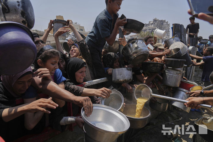 [가자시티=AP/뉴시스] 기아 위기가 고조되는 가자지구 가자시티에서 26일(현지 시간) 주민들이 힘겹게 식량을 받고 있다. 2025.07.26.