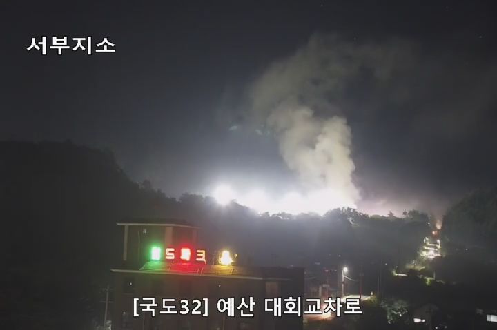 [예산=뉴시스] 26일 오후 2시31분께 충남 예산군 예산읍 대회리의 수해 쓰레기 적환장서 불이 나 연기가 하늘로 치솟고 있다. (사진=한국도로공사 CCTV 갈무리) 2025.07.26. photo@newsis.com *재판매 및 DB 금지