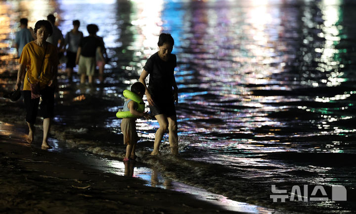 [포항=뉴시스] 이무열 기자 = 폭염경보와 열대야 현상으로 인해 밤낮으로 푹푹 찌는 무더위가 이어진 26일 밤 경북 포항시 북구 영일대해수욕장에서 시민과 관광객들이 더위를 식히고 있다. 2025.07.26. lmy@newsis.com