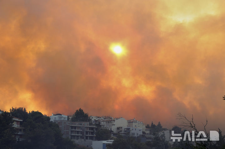 [아테네= AP/뉴시스] 그리스의 수도 아테네 북서부 교외인 크리요네리 지역에서 7월 26일 일어난 산불로 짙은 연기가 대낮에도 태양을 가리고 있다.  2025. 07.27. 