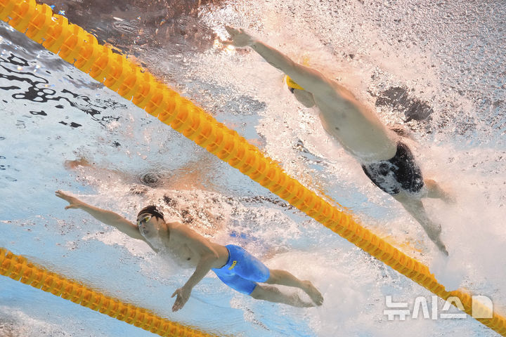 [싱가포르=AP/뉴시스] 김우민(강원도청·사진 왼쪽)이 27일 싱가포르 세계수영선수권대회 아레나에서 열린 2025 세계수영연맹 세계선수권대회 경영 남자 자유형 400m 예선에서 역영을 펼치고 있다. 2025.07.27