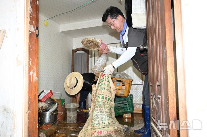 [합천=뉴시스]BNK금융그룹 빈대인 회장이 25일 경남 합천군 가회면 덕촌리 한 마을을 찾아 집중호우로 유입된 토사 제거 등 피해 복구 활동에 힘을 보태고 있다.(사진=BNK금융그룹 제공)2025.07.27. photo@newsis.com 