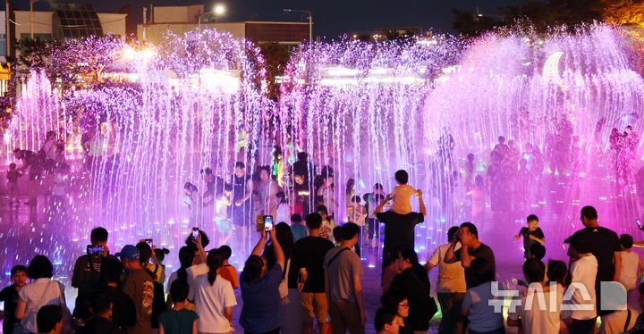 [부산=뉴시스] 하경민 기자 = 밤낮으로 푹푹 찌는 더위가 이어진 26일 밤 부산 사하구 다대포 꿈의 낙조분수를 찾은 어린이 등이 시원한 물줄기를 맞으며 더위를 식히고 있다. 2025.07.27. yulnetphoto@newsis.com