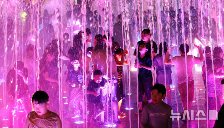 [부산=뉴시스] 하경민 기자 = 밤낮으로 푹푹 찌는 더위가 이어진 26일 밤 부산 사하구 다대포 꿈의 낙조분수를 찾은 어린이 등이 시원한 물줄기를 맞으며 더위를 식히고 있다. 2025.07.27. yulnetphoto@newsis.com