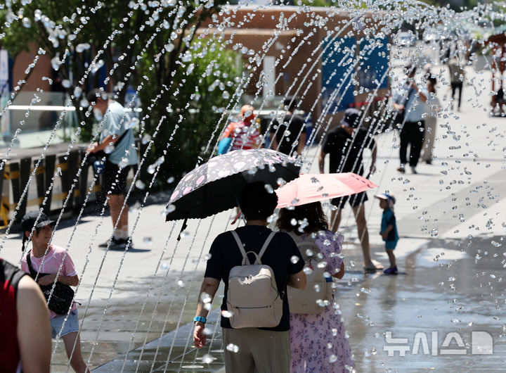 [서울=뉴시스] 배훈식 기자 = 전국 대부분 지역에 폭염특보가 내려진 27일 오전 서울 종로구 광화문광장에서 시민들이 분수터널을 걸으며 더위를 식히고 있다. 2025.07.27. dahora83@newsis.com