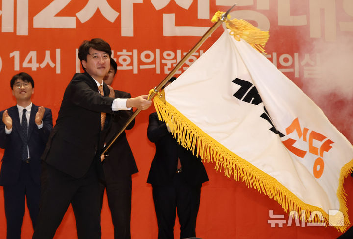 [서울=뉴시스] 김명년 기자 = 이준석 개혁신당 대표가 27일 오후 서울 여의도 국회 의원회관에서 열린 개혁신당 제2차 전당대회에서 당대표에 선출된 후 당기를 이양받아 흔들고 있다. 2025.07.27. kmn@newsis.conm