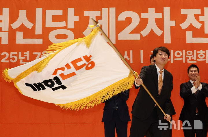[서울=뉴시스] 김명년 기자 = 이준석 개혁신당 대표가 27일 오후 서울 여의도 국회 의원회관에서 열린 개혁신당 제2차 전당대회에서 당대표에 선출된 후 당기를 이양받아 흔들고 있다. 2025.07.27. kmn@newsis.conm