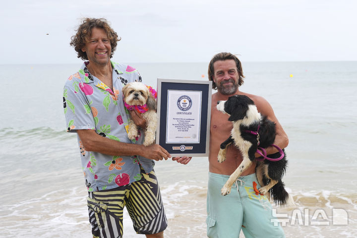 [풀=AP/뉴시스] 27일(현지 시간) 영국 도싯주 풀 인근에서 열린 '2025 도그 마스터스 페스티벌' 패들보드 대회 '기네스 기록' 부문에서 우승한 맷 젠킨스와 반려견 지지(왼쪽), 벤 그레이와 반려견 부가 기네스 인증서를 들고 기념 촬영하고 있다. 이들은 '사람과 반려견 패들보드 50m 최단 기록' 부문에서 32초로 공동 우승하며 인증서를 받았다. 이 대회는 '사람과 반려견 패들보드', '반려견 단독 서핑', '기네스 기록 도전' 등의 부문으로 나뉘어 열린다. 2025.07.28.