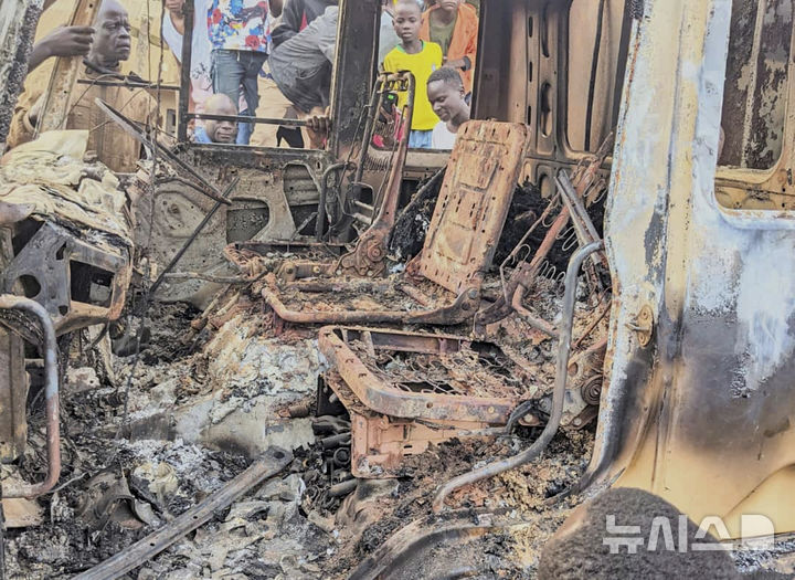 [코만다=AP/뉴시스] 민주콩고 동부 이투리주 코만다의 한 성당에서 지난 7월 27일 무장 괴한들의 공격ㅇ로 38명이 죽은 뒤 잔해만 남은 차량 주변에 사람들이 모여 있다. 유엔은 민주콩고 내전과 통제로 수십만 명의 난민들에 대한 구호품 전달이 막혔다고 11월 26일 보고했다. 2025.11.27.