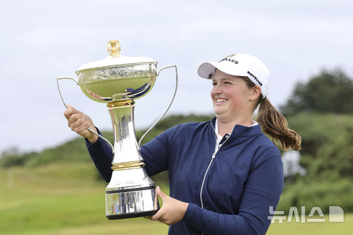 [에어셔=AP/뉴시스] 로티 워드(영국)가 27일(현지 시간) 스코틀랜드 에어셔의 던도널드 링크스에서 열린 미국여자프로골프(LPGA)투어·유러피언투어(LET) ISPS 한다 위민스 스코틀랜드 오픈 정상에 올라 트로피를 들고 활짝 웃고 있다. 불과 1주일 전에 프로로 전향한 워드는 최종 합계 21언더파 267타를 기록하며 프로 데뷔전 우승을 차지했다. 2025.07.28.