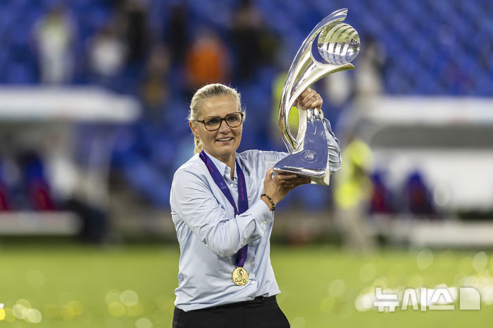 [바젤=AP/뉴시스] 잉글랜드 여자축구대표팀의 사리나 비흐만 감독이 27일(현지 시간) 스위스 바젤의 장크트야코프파크에서 열린 2025 유럽축구연맹(UEFA) 여자 유로 결승에서 스페인을 꺾고 우승한 후 트로피를 들어 올리고 있다. '디펜딩 챔피언' 잉글랜드는 결승전에서 스페인과 1-1로 비겨 승부차기 끝에 3-1로 승리하고 2연패를 달성했다. 2025.07.28.