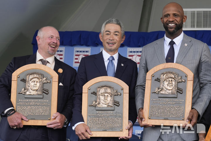 [쿠퍼스타운=AP/뉴시스] 스즈키 이치로(가운데)가 27일(현지 시간) 미 뉴욕주 쿠퍼스타운에서 열린 미국 야구 명예의 전당 헌액식에서 빌리 와그너(왼쪽), CC 사바시아와 함께 명판을 들고 포즈를 취하고 있다. 그는 "51세가 된 지금도 야구에서 멀어지지 않은 것이 행복하다"라고 소감을 말했다. 2025.07.28.