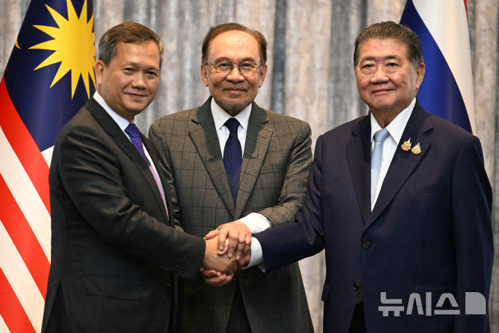 [푸트라자야(말레이시아)=AP/뉴시스]안와르 이브라힘 말레이시아 총리(가운데)와 훈 마네 캄보디아 총리(왼쪽), 품탐 웨차야차이 태국 총리대행(당시)이 7월28일 말레이시아 푸트라자야에서 5일 간 계속된 태국과 캄보디아 간 치명적 국경 충돌을 해결을 위한 휴전회담이 끝난 후 악수하고 있다. 말레이시아와 미국은 이달 말 동남아 정상회담에서 체결되기를 희망하는 태국과 캄보디아 간의 확대된 휴전협정을 확보하기 위한 노력을 촉진하고 있다고 모하메드 하산 말레이시아 외무장관이 14일 말했다. 2025.10.14.