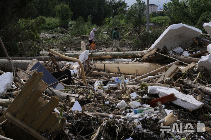 [미원=AP/뉴시스] 28일(현지 시간) 중국 베이징 외곽 미원구 타이시툰에 내린 폭우로 나뭇가지 등 잔해가 널브러져 있다. 2025.07.29.