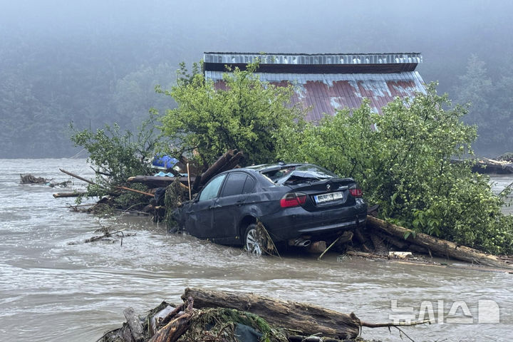 [부카레스트( 루마니아)=AP/뉴시스]루마니아 북부를 휩쓴 폭우와 돌발 홍수등 악천후로 북부 브로스테니 마을의 주택과 차량이 7월 28일 급류에 휩쓸린 광경.  루마니아의 다뉴브 삼각주 일대에서도 이 날 여객선 침몰사고로 4명이 물에 빠져 숨졌다. 2025. 07.29. 