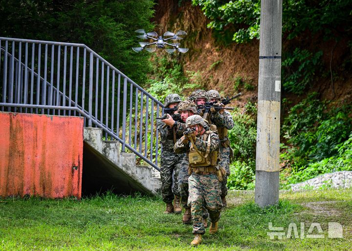 [인천=뉴시스] 정일형 기자 = 한미 해병대 장병들이 연합으로 팀을 편성해 드론과 함께 기동하며 진입로를 확보하고 있다. (사진=해병대 2사단 제공)