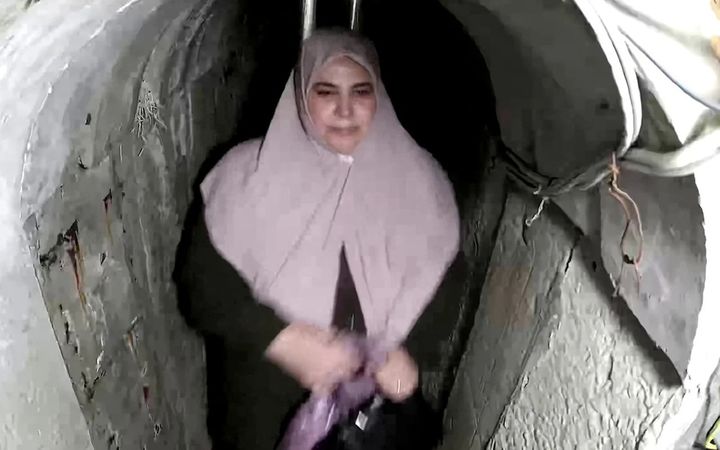 [뉴시스] 팔레스타인 무장정파 하마스 최고 지도자 야히야 신와르의 부인인 사마르 무하마드 아부 자마르가 명품 가방을 들고 하마스 터널을 통해 탈출하는 모습. (사진=이스라엘군) 2025.7.28 *재판매 및 DB 금지