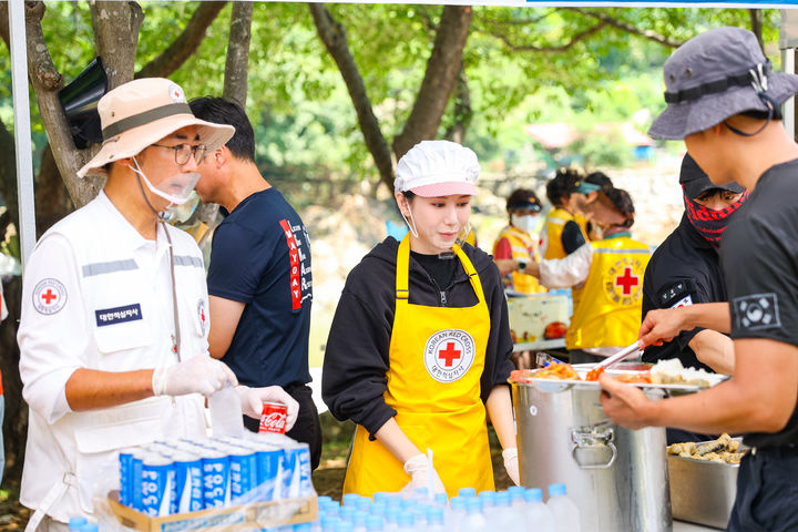 [수원=뉴시스] 대한적십자사 안재욱 홍보대사와 김민지 영양사가 26일 수해복구 현장에서 봉사활동을 하고 있다. (사진=경기적십자사 제공) 2025.07.28. photo@newsis.com *재판매 및 DB 금지