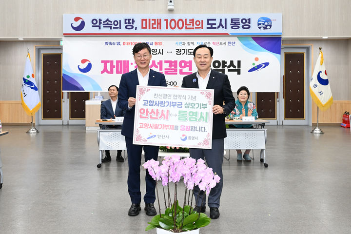 [안산=뉴시스] 이민근 안산시장(사진 왼쪽)과 천영기 통영시장이 25일 친선 결연 협약식에서 고향사랑기부금을 상호 기부하고 함께 기념촬영을 하고 있다.(사진=안산시 제공)2025.07.28.photo@newsis.com *재판매 및 DB 금지