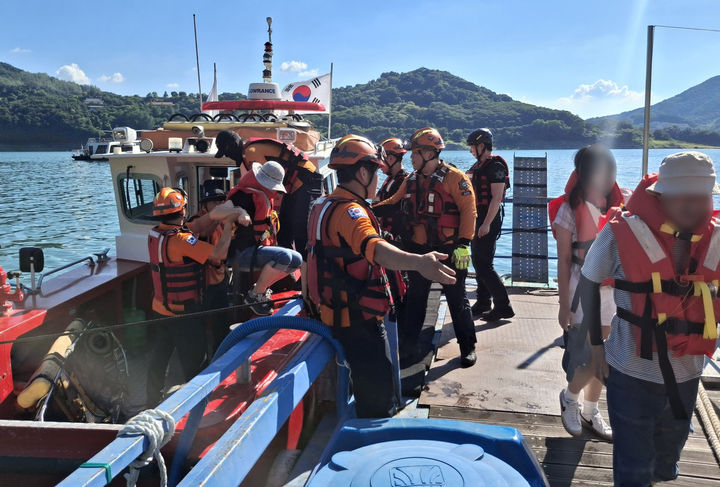 [제천=뉴시스] 이병찬 기자 = 28일 오후 충북 제천시 청풍면 충주호에서 고장난 유람선 승객들이 제천소방서 소방정을 통해 계류장에 구조되고 있다. (사진=제천소방서 제공) 2025.07.28. photo@newsis.com *재판매 및 DB 금지