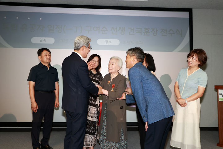 [의령=뉴시스]오태완(왼쪽) 의령군수가 구여순 지사 건국훈장을 딸 구철희 여사에게 전수하고 있다.(사진=의령군 제공) 2025.07.28.photo@newsis.com *재판매 및 DB 금지
