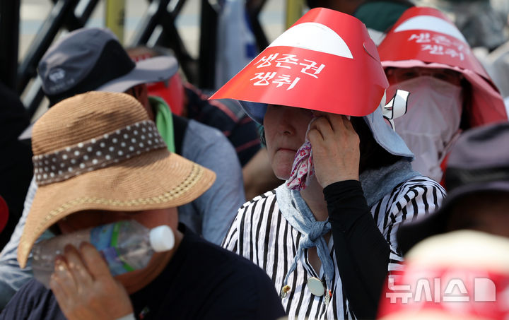 [서울=뉴시스] 조성우 기자 = 28일 오후 서울 용산구 대통령 인근에서 열린 한-미 상호관세 협상 농축산물 개방 반대 전국농축산인 결의대회에서 한 참가자가 땀을 닦고 있다. 2025.07.28. xconfind@newsis.com