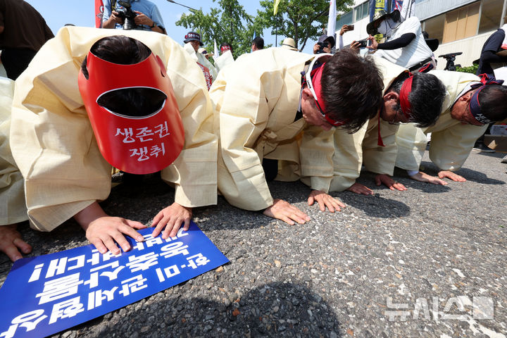 [서울=뉴시스] 조성우 기자 = 28일 오후 서울 용산구 대통령 인근에서 열린 한-미 상호관세 협상 농축산물 개방 반대 전국농축산인 결의대회에서 농민들이 상복을 입고 농축산물에 절하는 상징의식을 하고 있다. 2025.07.28. xconfind@newsis.com