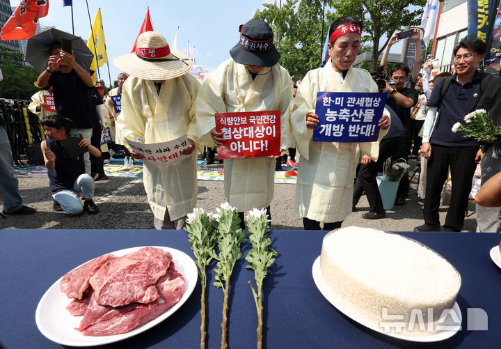 [서울=뉴시스] 조성우 기자 = 28일 오후 서울 용산구 대통령 인근에서 열린 한-미 상호관세 협상 농축산물 개방 반대 전국농축산인 결의대회에서 농민들이 한우와 쌀 등에 묵념하는 상징의식을 하고 있다. 2025.07.28. xconfind@newsis.com