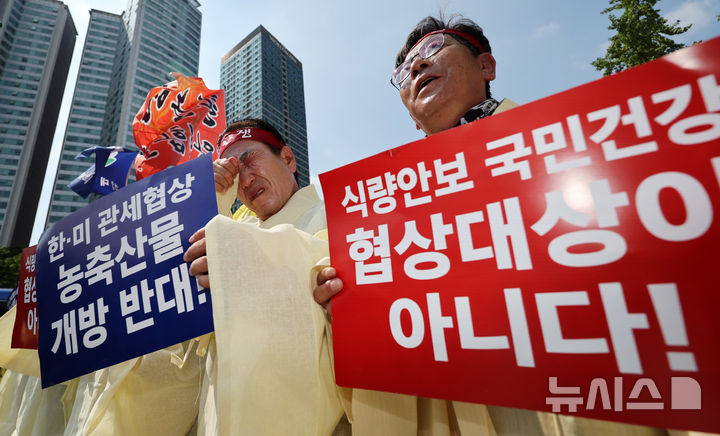 [서울=뉴시스] 조성우 기자 = 28일 오후 서울 용산구 대통령 인근에서 열린 한-미 상호관세 협상 농축산물 개방 반대 전국농축산인 결의대회에서 농민들이 상복을 입고 피켓팅을 하고 있다. 2025.07.28. xconfind@newsis.com