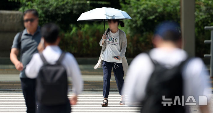 [서울=뉴시스] 김선웅 기자 = 서울 낮 최고기온이 37도를 기록하는 등 전국 대부분 지역에 폭염이 기승을 부린 28일 오후 서울 여의도에서 한 시민이 양산으로 햇빛을 가리고 있다. 2025.07.28. mangusta@newsis.com