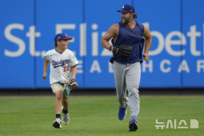 [신시내티=AP/뉴시스] LA 다저스 투수 클레이튼 커쇼가 28일(현지 시간) 미 오하이오주 신시내티의 그레이트 아메리칸 볼파크에서 열리는 2025 메이저리그 신시내티 레즈와의 경기에 앞서 아들 찰리와 경기장을 달리고 있다. 커쇼는 이날 경기에는 나서지 않는다. 2025.07.29.