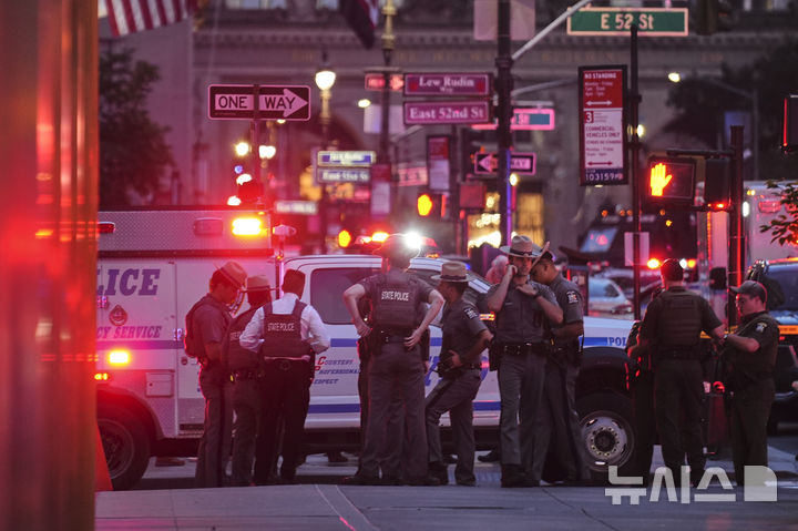 [뉴욕=AP/뉴시스] 28일(현지 시간) 미국 뉴욕 52번가 파크 애비뉴와 렉싱턴 애비뉴 사이 고층 건물에서 총격이 발생한 후 경찰이 현장 주변에 모여 있다. 2025.07.29.
