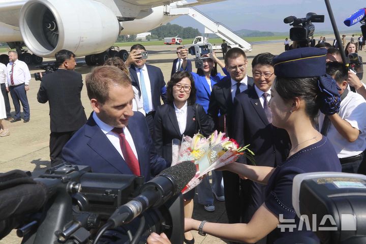 [평양=AP/뉴시스] 알렉산드르 코즐로프 러시아 천연자원부 장관이 대표단을 이끌고 7월 28일 북한 평양국제공항에 도착해 북한 승무원으로부터 꽃다발을 받고 있다. 러시아 대표단은 모스크바와 평양을 연결하는 첫 직항 여객기 편으로 평양에 도착했다. 2025.11.01.